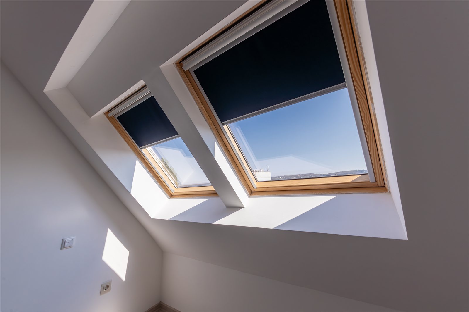 Zwei Velux-Dachfenster mit Rollo in der Dachschräge – Sonnen- und Hitzeschutz unter dem Dach